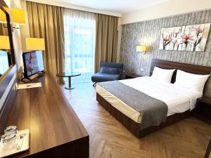 ein Hotelzimmer mit Bett und Fernseher in der Unterkunft Hotel Arnia in Iaşi
