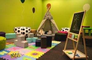 a room with a play area with a play tent at Leonardo Hotel Weimar in Weimar