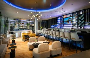 a bar in a hotel with chairs and a counter at Leonardo Royal Hotel Cologne Bonn Airport in Cologne