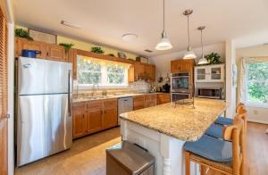 a kitchen with a white refrigerator and wooden cabinets at Pappia - Duck, Sanderling, Oceanside, 150 Yards to Beach, on Lake, Community Pool in Duck