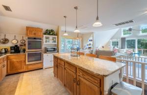 a large kitchen with wooden cabinets and a counter top at Pappia - Duck, Sanderling, Oceanside, 150 Yards to Beach, on Lake, Community Pool in Duck +47 photos