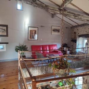 a living room with a red couch in a room at Gite l'Etape in Vallon-Pont-dʼArc