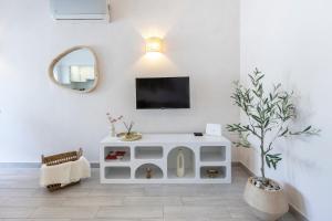 a living room with a tv on a white wall at Albufeira City Centre Apartment with Pool in Albufeira