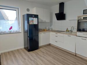 a kitchen with a black refrigerator and a window at Apartment house Petra in Cerklje na Gorenjskem