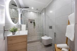 a bathroom with a toilet and a sink and a mirror at Albufeira City Centre Apartment with Pool in Albufeira