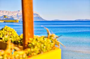 a cruise ship on the water with mountains in the background at Smeralda Apartment - Golfo Aranci in Golfo Aranci