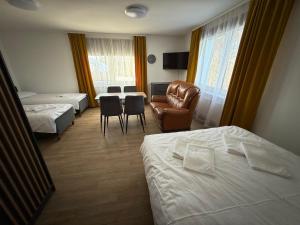 a hotel room with two beds and a chair at SALGIRDO svečių namai in Kelmė