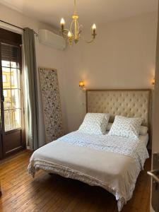 a bedroom with a bed with white sheets and a chandelier at Casa Balcones in Sahagún