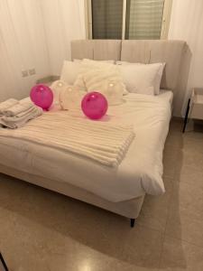 two pink balloons sitting on top of a bed at צימר בטבע in Majdal Shams