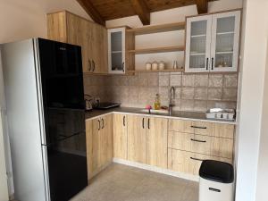 a kitchen with wooden cabinets and a black refrigerator at צימר בטבע in Majdal Shams