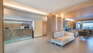 a woman standing at a counter in a lobby at Leonardo Royal Hotel Mallorca Palmanova Bay in Palmanova