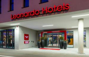 a store with a red sign on the front of it at Leonardo Hotel Augsburg in Augsburg
