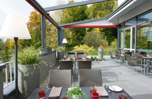 a restaurant with a patio with tables and chairs at Leonardo Hotel Völklingen-Saarbrücken in Völklingen +20 photos
