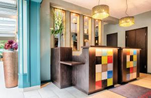 a lobby with a colorful counter and some lights at Leonardo Boutique Hotel Berlin City South in Berlin