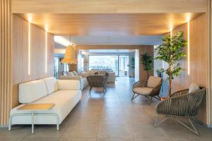 a living room with a white couch and chairs at Leonardo Royal Hotel Mallorca Palmanova Bay in Palmanova +40 photos