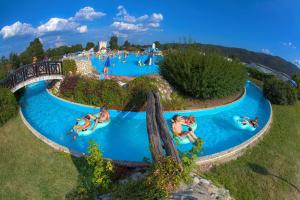 a group of people swimming in a pool at a water park at EMIA Family House Čatež in Brežice