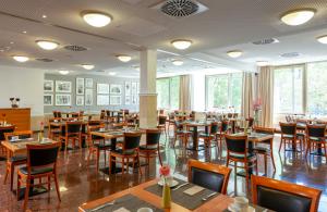 a dining room with wooden tables and chairs at Leonardo Hotel Berlin KU'DAMM in Berlin