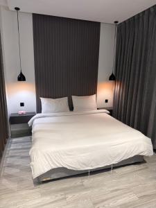 a bedroom with a large bed with white sheets at شاليهات سمو بارك in Taif