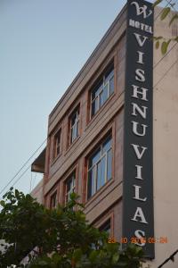 a sign for a hotel on the side of a building at Hotel Vishnu Vilas in Rewa