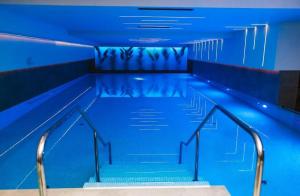 an empty swimming pool with stairs in a building at Luna Residence in Niš