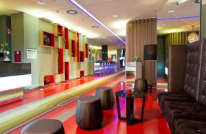a bowling alley with chairs and a table in a building at Leonardo Hotel Berlin Mitte in Berlin