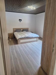 a bedroom with a bed and a wooden floor at Mirna zelena dolina in Šentilj