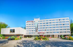 a large white building with a courtyard in front of it at Leonardo Royal Hotel Köln - Am Stadtwald in Cologne
