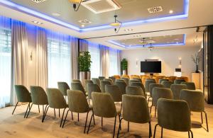 a conference room with chairs and a projection screen at Leonardo Hotel Hamburg Altona in Hamburg