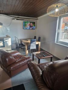 a living room with a leather couch and a table at Mirna zelena dolina in Šentilj