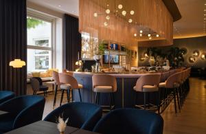 a bar in a restaurant with blue stools at Hotel Mannheimer Hof - Leonardo Limited Edition in Mannheim +60 photos