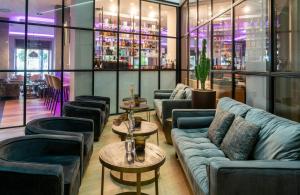 a lobby with couches and tables and a bar at NYX Hotel Bilbao by Leonardo Hotels in Bilbao