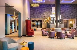 a lobby with a waiting room with chairs and tables at Leonardo Hotel Eschborn Frankfurt in Eschborn