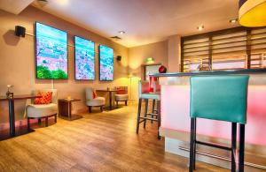 a bar with chairs and a counter in a room at Leonardo Hotel Heidelberg Walldorf in Walldorf