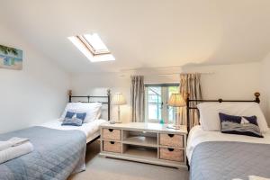 a bedroom with two beds and a desk and a window at 2 Bed in Bodham oc-2082 in Bodham