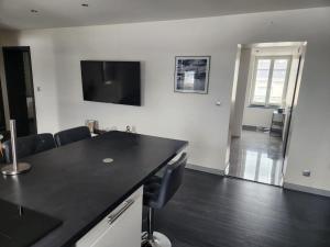 a kitchen with a black counter top and a living room at appartement Morteau in Morteau