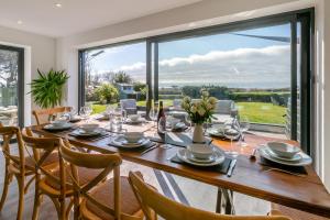 a dining room with a table and chairs and a large window at 5 Bed in Stibb oc-f31065 in Poughill