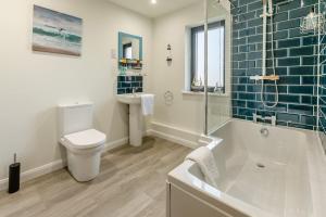 a bathroom with a tub and a toilet and a sink at 5 Bed in Stibb oc-f31065 in Poughill +37 photos