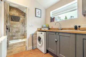 a bathroom with a washing machine and a shower at 3 Bed in Brancaster oc-h27159 in Brancaster