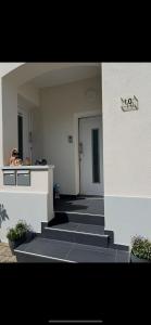 a woman taking a picture of a building with stairs at Maison letiluca in Hésingue