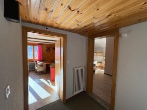 a living room with a wooden ceiling and a hallway at Alte Bock 2.0 in Grächen +83 photos