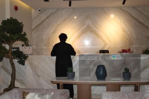 a person standing behind a table in a room at Albateel 2 Serviced Apartments-اقتصادي in Riyadh