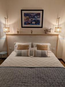 a large bed in a bedroom with two lights at Les Chambres De La Loge in Montmorillon