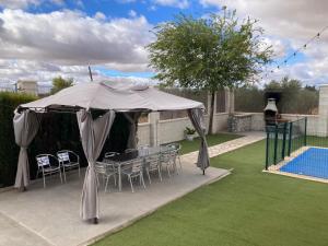 a patio with a table and chairs under a tent at Casa Rural Kentia in Valdepeñas