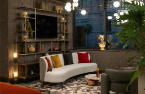 ein Wohnzimmer mit Sofa und Fernseher in der Unterkunft NYX Hotel Rome by Leonardo Hotels in Rom