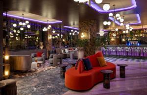 Eine Lobby mit einer roten Couch inmitten einer Bar in der Unterkunft NYX Hotel Rome by Leonardo Hotels in Rom + 47 Fotos