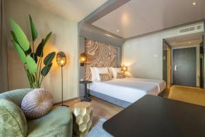 a bedroom with a bed and a table and a couch at Leonardo Hotel Breda City Center in Breda