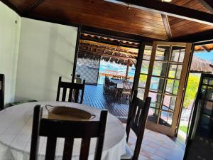 a dining room with a table and chairs and a patio at Casa do Abrahão in Angra dos Reis