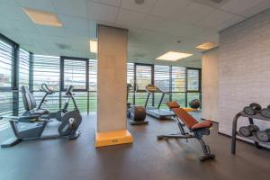 a gym with several exercise equipment in a building at Leonardo Hotel Groningen Stadspark in Groningen