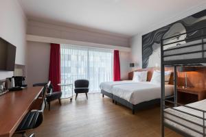 a hotel room with a bed and a desk at Leonardo Hotel Utrecht City Center in Utrecht