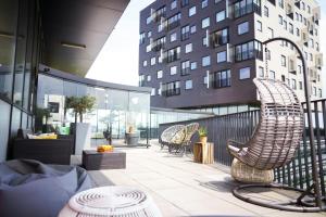 a patio with chairs and tables and a building at Leonardo Hotel Groningen Stadspark in Groningen